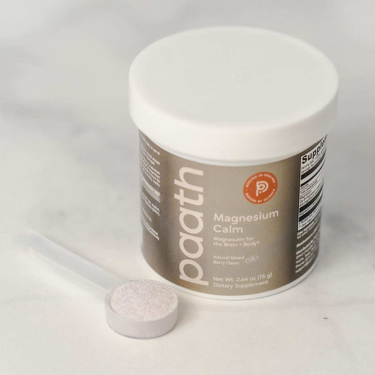 Supplement container labeled 'paith Magnesium Calm' with a white pill on a light gray background