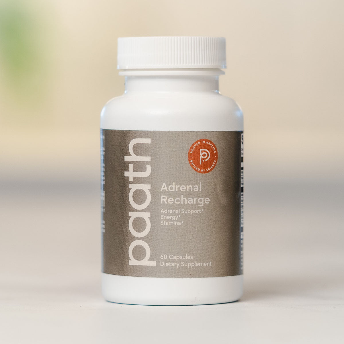 Supplement bottle labeled 'Adrenal Recharge' by 'path' on a neutral background