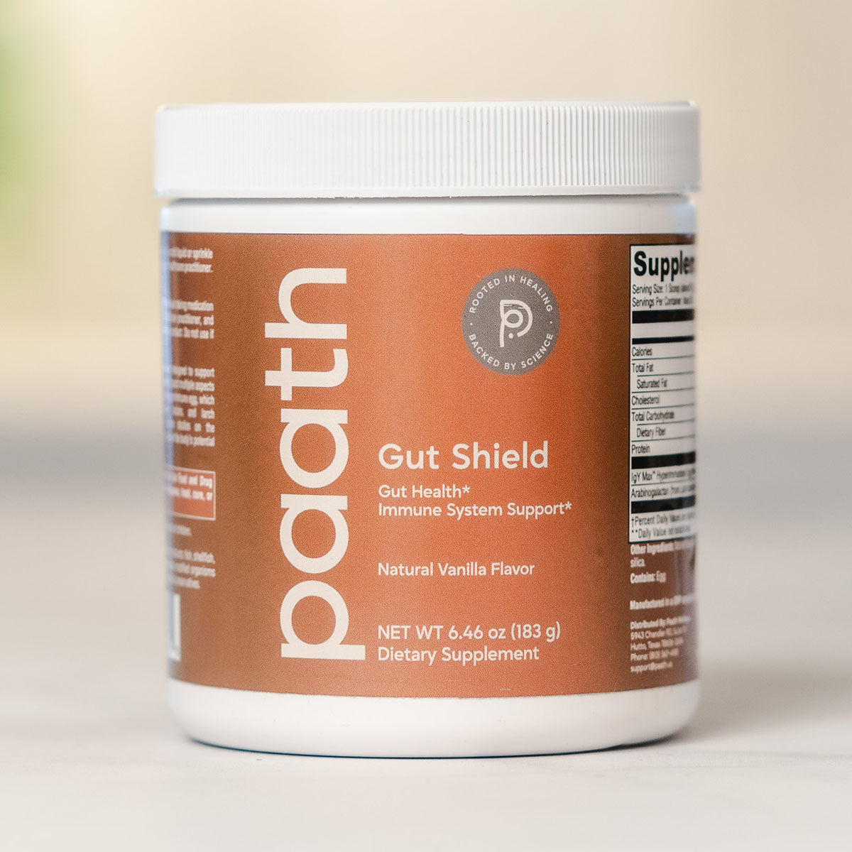 Supplement container labeled 'paath Gut Shield' on a neutral background