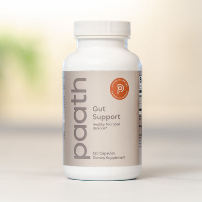 Supplement bottle labeled 'paath Gut Support' on a blurred background