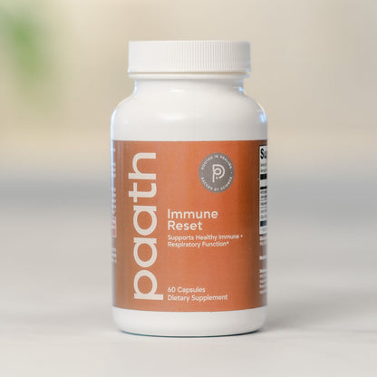 Supplement bottle labeled 'paath Immune Reset' on a neutral background