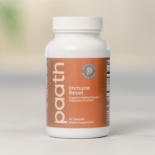 Supplement bottle labeled 'paath Immune Reset' on a neutral background