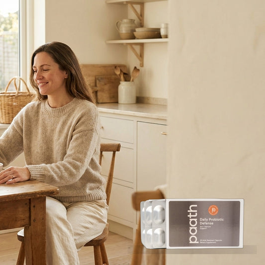 Woman comfortable and light after eating in a bright kitchen with Paath Daily Probiotic Defense